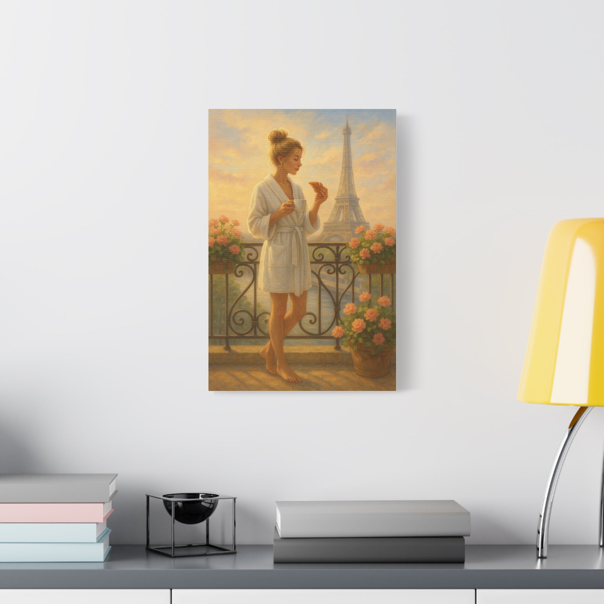 Framed artwork of a woman in a bathrobe on a wall above a desk with books and a lamp.