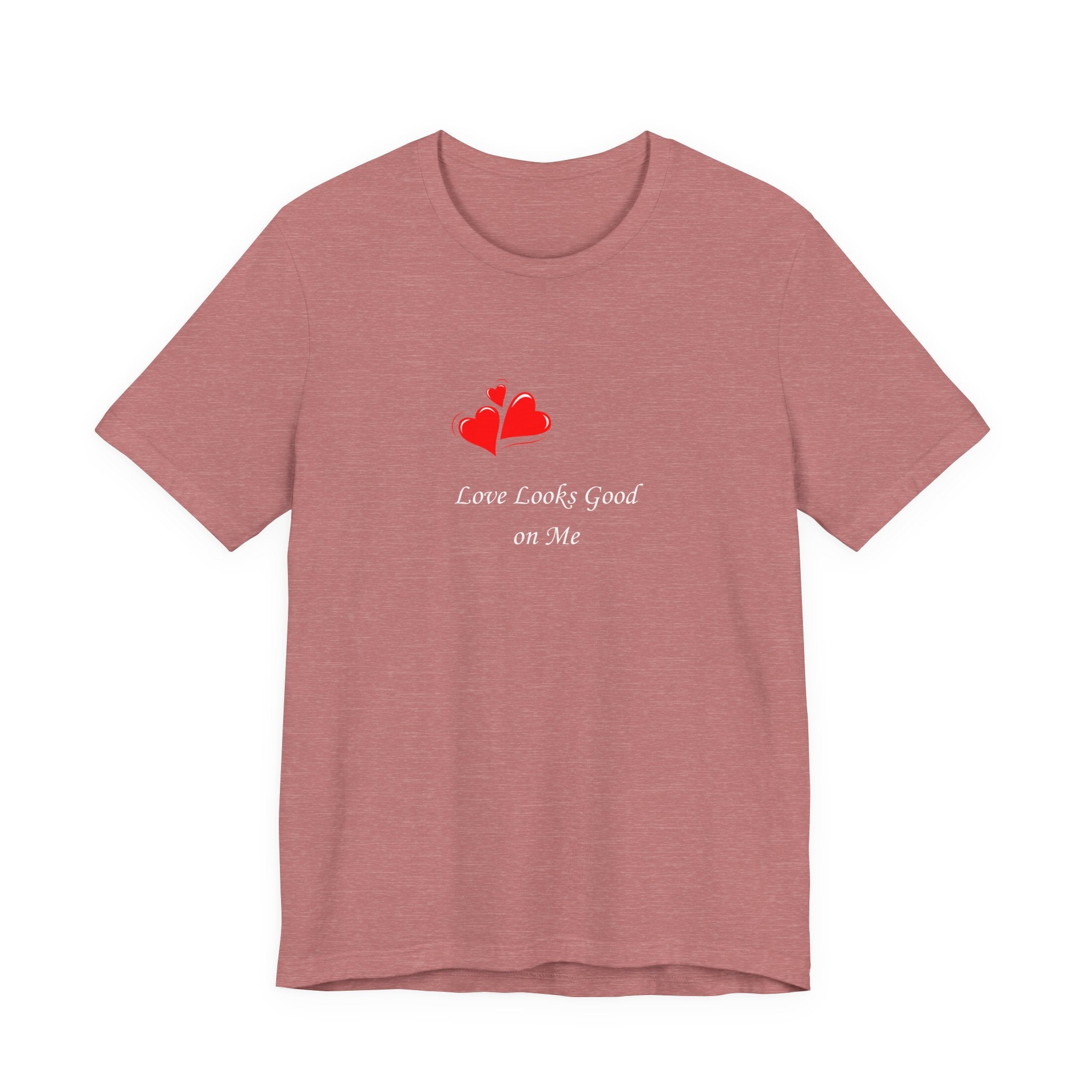 Pink t-shirt with red heart design and text on a white background