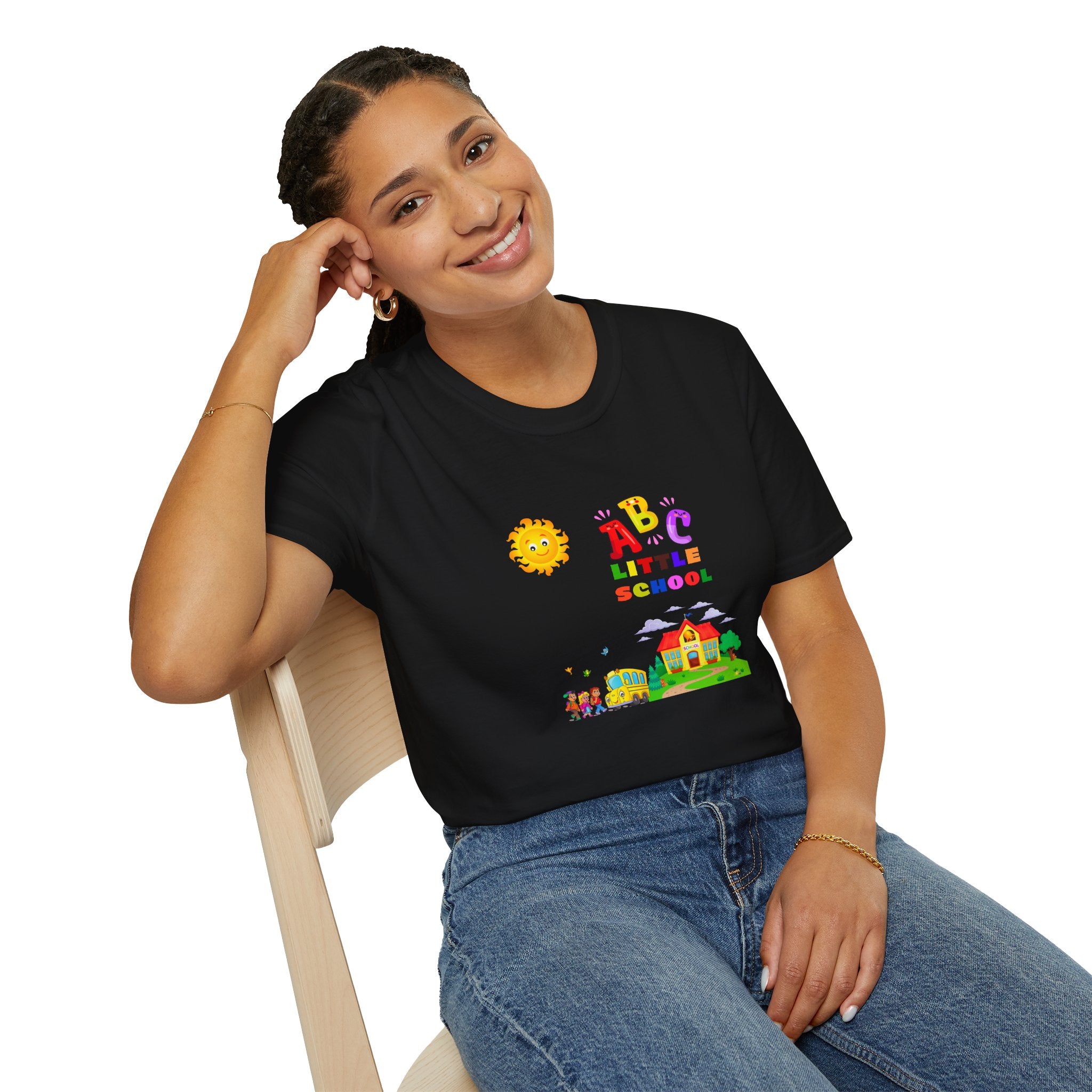 Person wearing a black t-shirt with colorful graphics and text, sitting on a chair.
