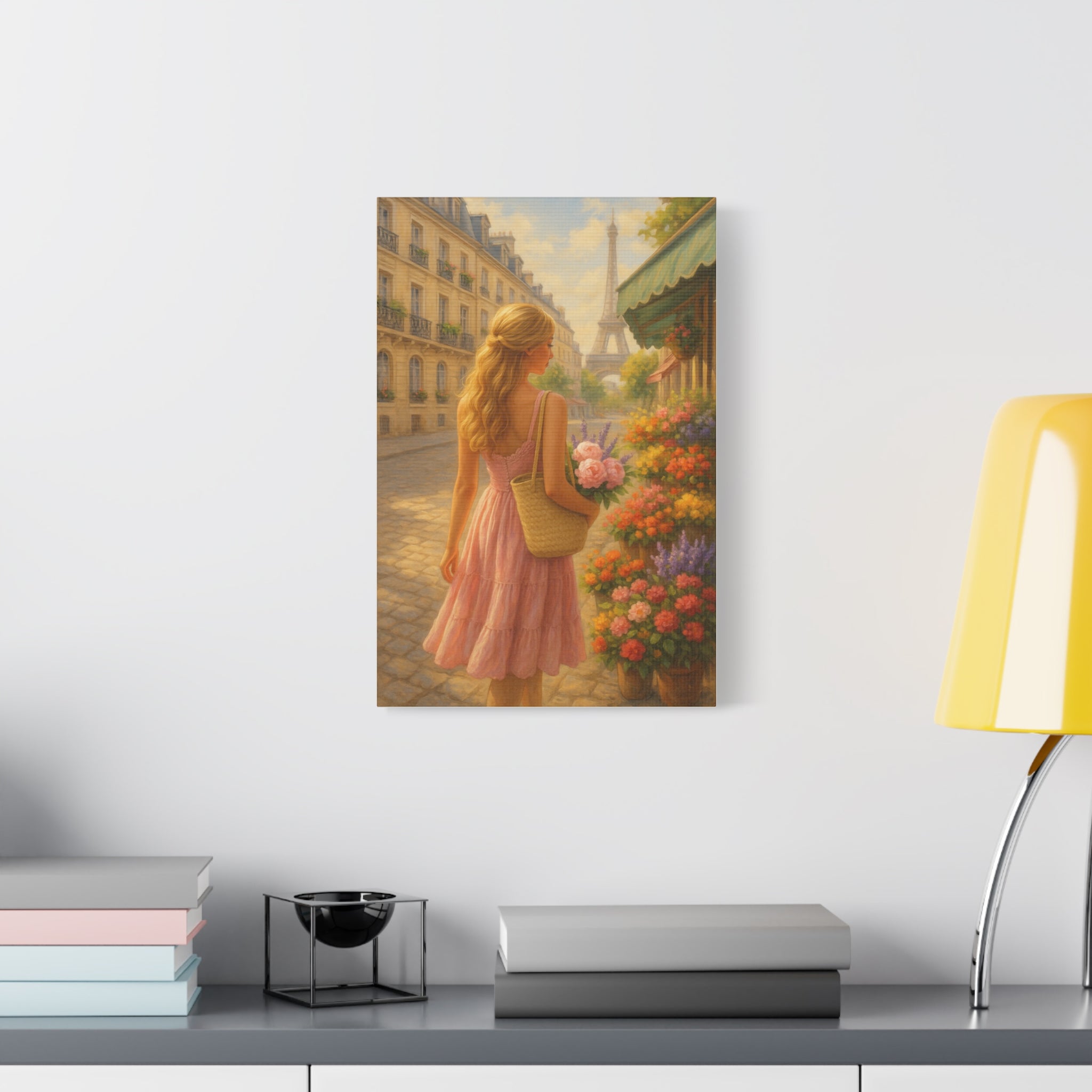 Framed artwork of a woman in a pink dress holding flowers on a Paris street, displayed on a shelf.