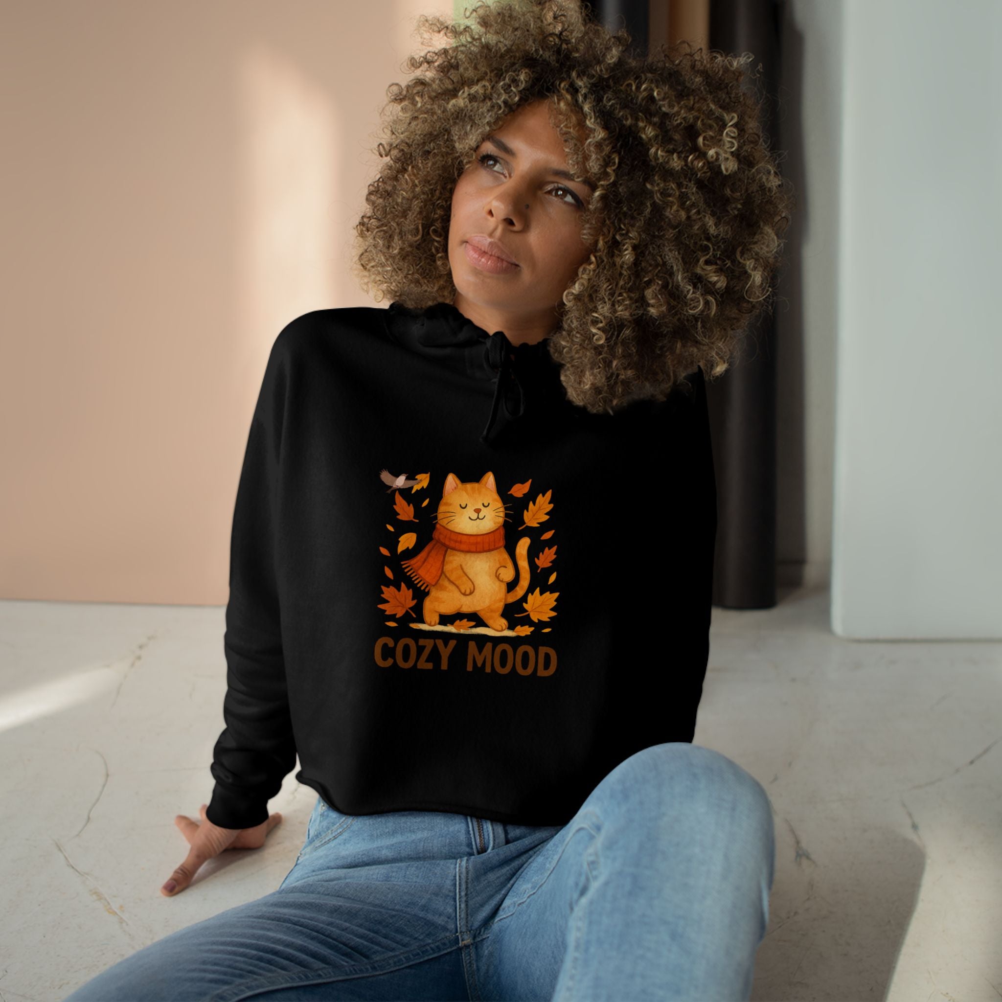 Person wearing a black hoodie with a cat graphic and 'Cozy Mood' text, sitting indoors.