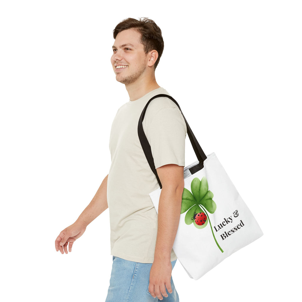 Man carrying a tote bag with a four-leaf clover design and 'lucky & blessed' text.